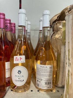 Plusieurs bouteilles de vin sont alignées sur une étagère dans un réfrigérateur
