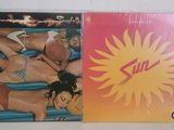 two cd ' s with a picture of a woman in bikinis laying on an inflatable mattress