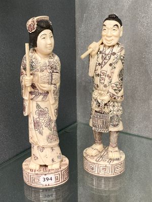 deux figurines représentant des personnes d'origine asiatique exposées dans une vitrine