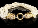 un gros plan d'un bracelet orné de perles sur un fond noir