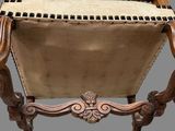 a chair that is made of wood and has a seat made of fabric