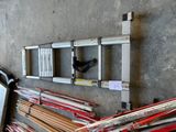 a ladder that is leaning against a wall next to a pile of skis