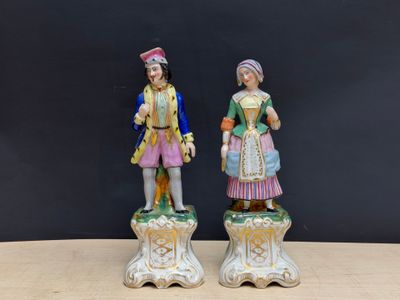 deux figurines représentant un homme et une femme debout sur une table en bois
