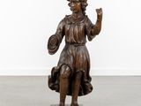 an antique bronze statue of a woman holding a basket