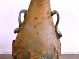 un vase posé par terre devant un mur