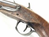 an old gun with a wooden handle on a white surface