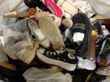many pairs of shoes that are piled together on a bed