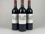 trois bouteilles de vin rouge posées côte à côte sur une table