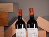 two bottles of wine sitting next to each other on a table