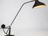 une lampe de bureau noire surmontée d'une ampoule blanche