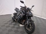 une photo d'une moto noire garée sur un sol à damier