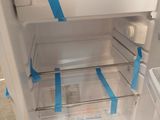 a white refrigerator with blue tape on the door