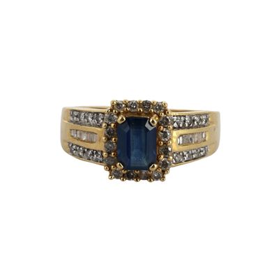 gros plan d'une bague avec une pierre bleue entourée de diamants