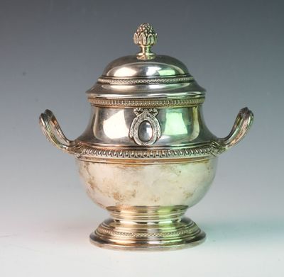 a silver vase with a lid on a white table