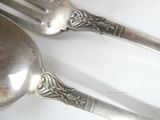 two spoons and a fork sitting on a table