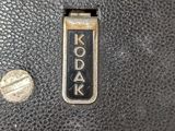 a close up of a black leather bag with a small coin on it