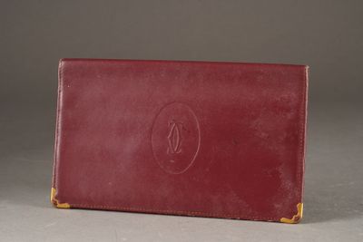 an old red leather wallet with a monogram on the front