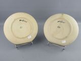 pair of yellow plates with black writing on them sitting on a metal stand