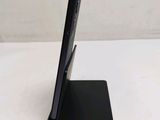 a black cell phone on a black stand on a table