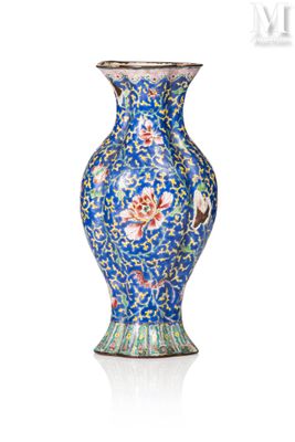 un vase bleu orné de fleurs, posé sur une surface blanche