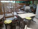 plusieurs tables et tabourets dans une pièce très meublée