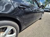 a black car that is parked on the side of the road
