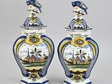 deux vases bleus et blancs surmontés d'un oiseau