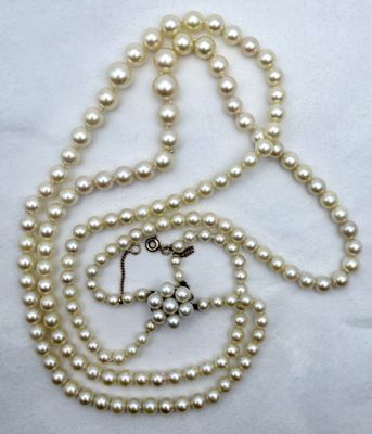 un gros plan sur un collier orné de perles et d'une croix