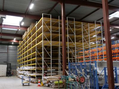 un grand entrepôt rempli d'étagères et de palettes