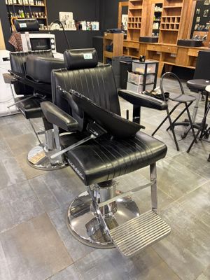 many black chairs in a room with a lot of books on the shelves