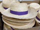 several straw hats are stacked on top of each other in a cardboard box