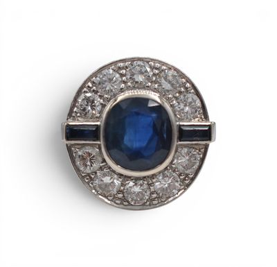 gros plan d'une bague avec une pierre bleue entourée de diamants blancs