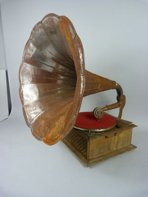 un vieux gramophone posé sur une table recouverte d'un coussin rouge