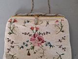 an old purse hanging on a wall with a rope around it