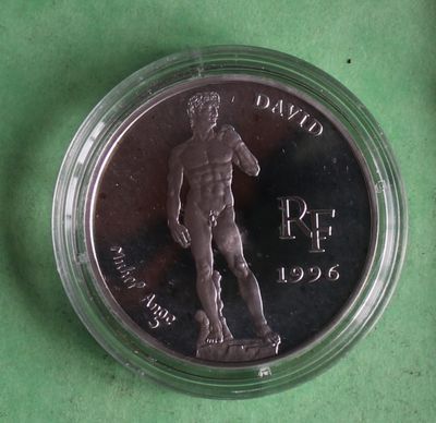 a close up of a coin in a plastic container on a green surface