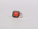 a close up of a ring with a red stone in it
