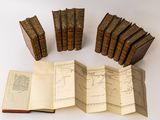 several old books sitting on top of each other on a table