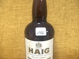 une photo d'une bouteille de whisky Haig posée sur une table