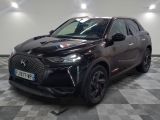 une voiture noire garée dans un garage au sol en damier