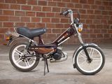 a small motorcycle that is parked in front of a brick wall