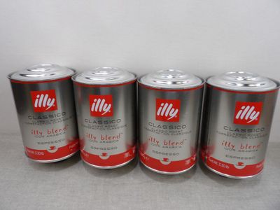 quatre boîtes de café Illy sont posées sur un plan de travail