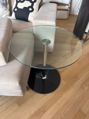 une table en verre avec un piètement noir dans un salon