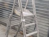 two ladders sitting next to each other in front of a garage door