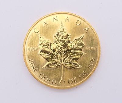 pièce d'or représentant une feuille d'érable sur un fond blanc
