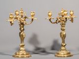 une paire de chandeliers anciens en laiton, ornés chacun de fleurs