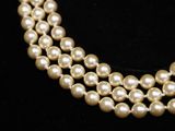 three strand pearl necklace on a black background