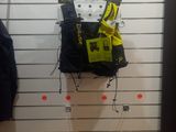 a black jacket hanging on a white wall next to a pair of black pants