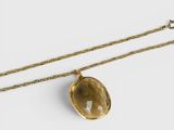un collier en or orné d'une pierre de quartz jaune facettée, monté sur une chaîne en or