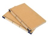 two brown notebooks are stacked on top of each other