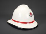 white fireman ' s hat with red band and emblem on it